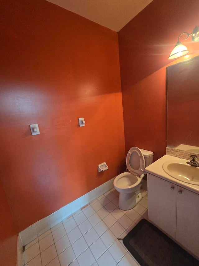 bathroom with toilet, vanity, and tile patterned floors