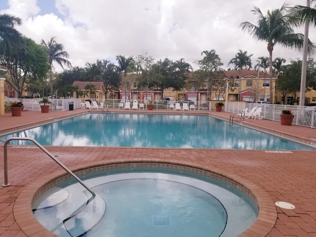 view of pool with a community hot tub and a patio area