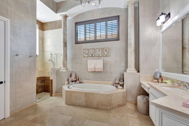 bathroom with tile walls, shower with separate bathtub, decorative columns, and vanity