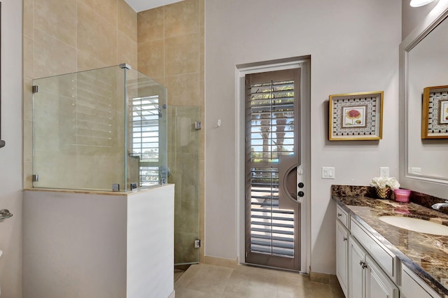 bathroom with an enclosed shower, a wealth of natural light, vanity, and tile patterned floors