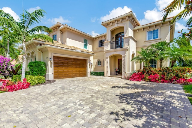 mediterranean / spanish house featuring a balcony and a garage