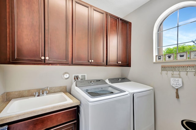 laundry room with cabinets, separate washer and dryer, and sink