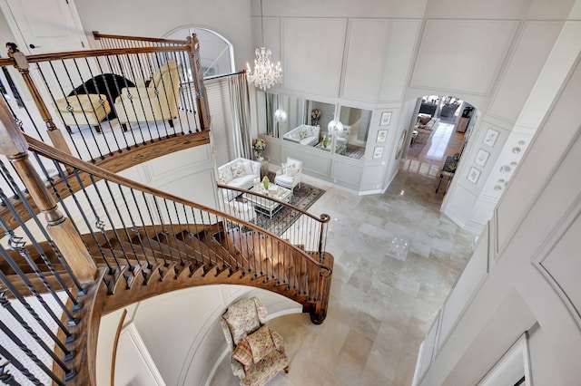 staircase featuring a chandelier and a towering ceiling