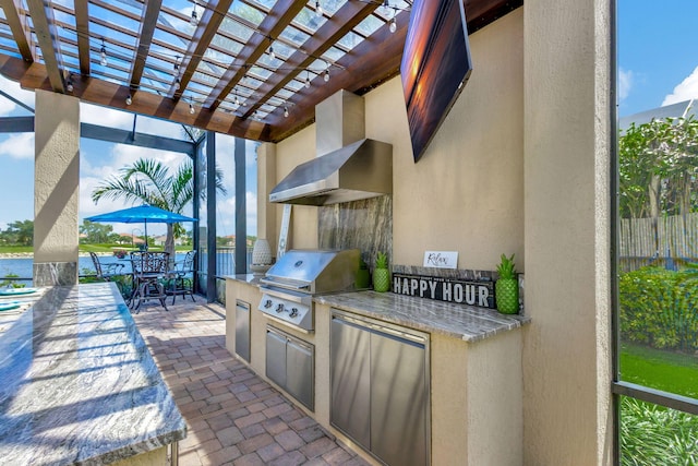 view of patio featuring exterior kitchen, a pergola, and a grill