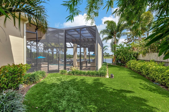 view of yard featuring a fenced in pool and glass enclosure