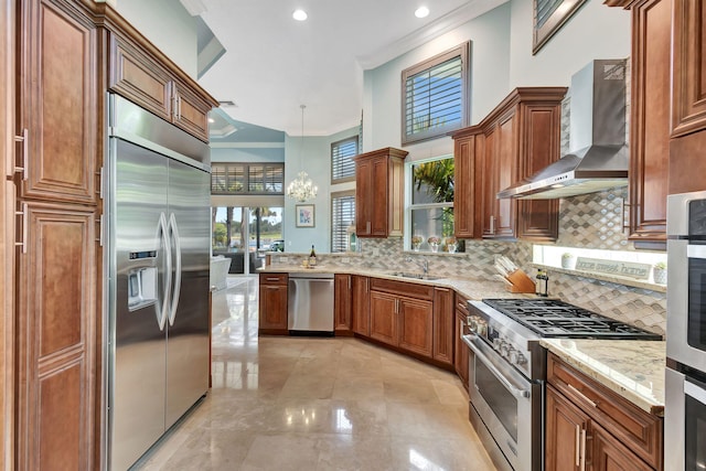 kitchen featuring wall chimney exhaust hood, sink, high quality appliances, crown molding, and decorative light fixtures