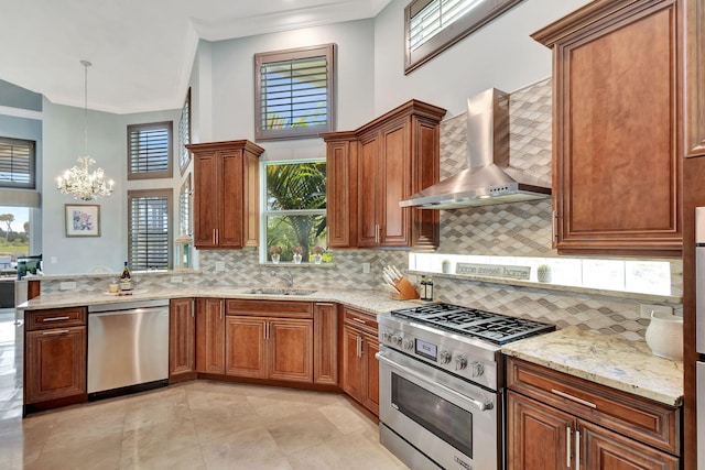 kitchen with appliances with stainless steel finishes, wall chimney exhaust hood, backsplash, decorative light fixtures, and crown molding