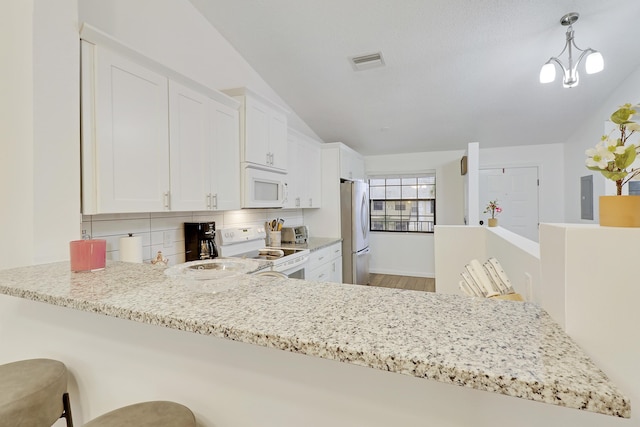 kitchen featuring light stone counters, white appliances, visible vents, white cabinetry, and backsplash