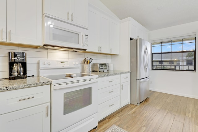 kitchen featuring light stone counters, light wood-style flooring, white appliances, white cabinets, and backsplash