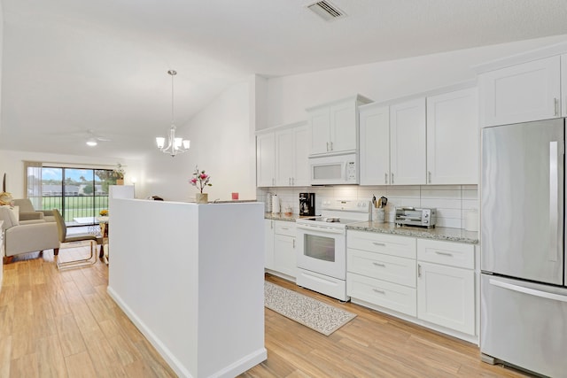 kitchen featuring white cabinetry, decorative light fixtures, white appliances, light wood-type flooring, and vaulted ceiling