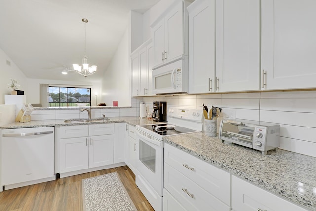 kitchen with white appliances, a sink, white cabinetry, decorative backsplash, and light wood finished floors