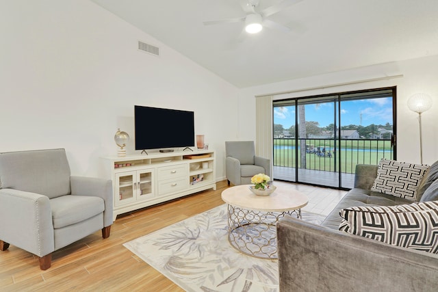 living room featuring hardwood / wood-style flooring, ceiling fan, and vaulted ceiling