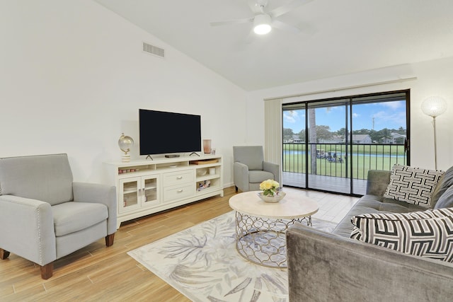 living area featuring a ceiling fan, lofted ceiling, visible vents, and light wood finished floors