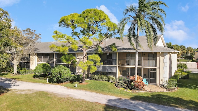 view of front of house with a balcony and a front yard