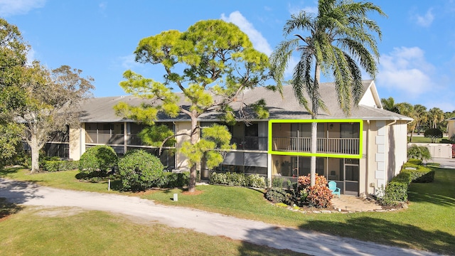 view of front facade with a front lawn and a sunroom