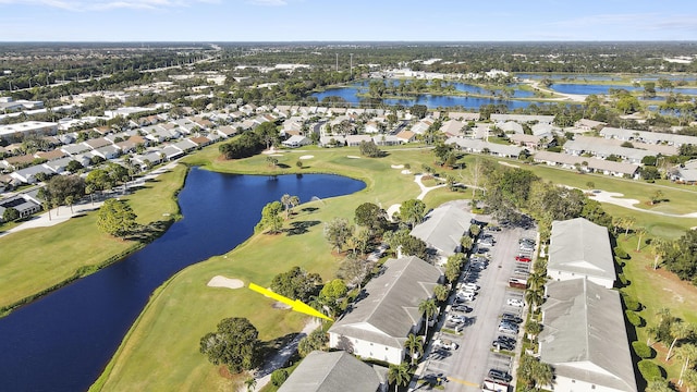 drone / aerial view featuring golf course view, a water view, and a residential view