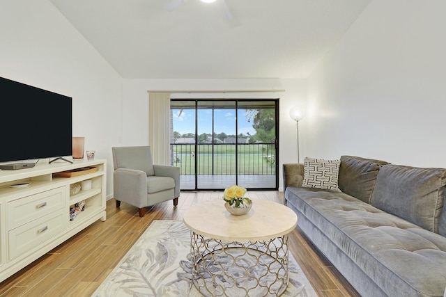 living room with light wood-style floors and vaulted ceiling