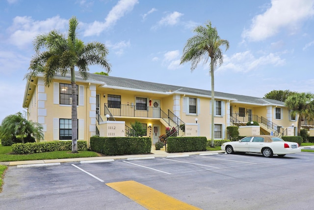 view of building exterior featuring uncovered parking and stairs