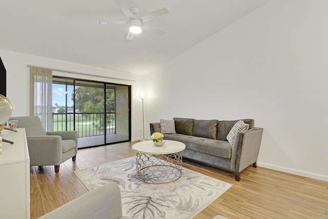 living area featuring lofted ceiling, ceiling fan, baseboards, and wood finished floors