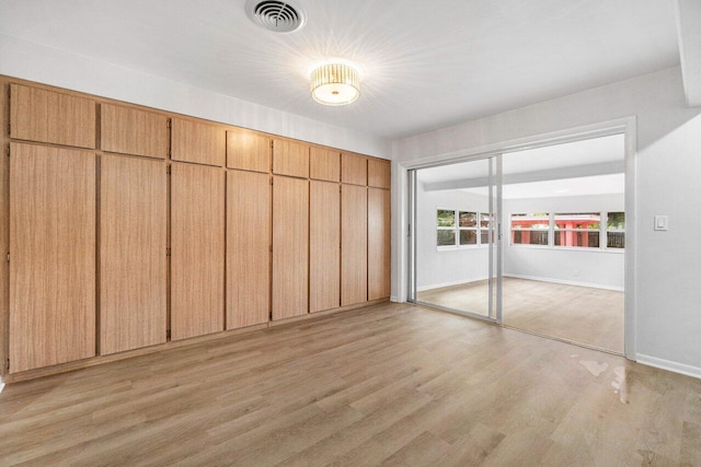 unfurnished bedroom with light hardwood / wood-style flooring and a closet