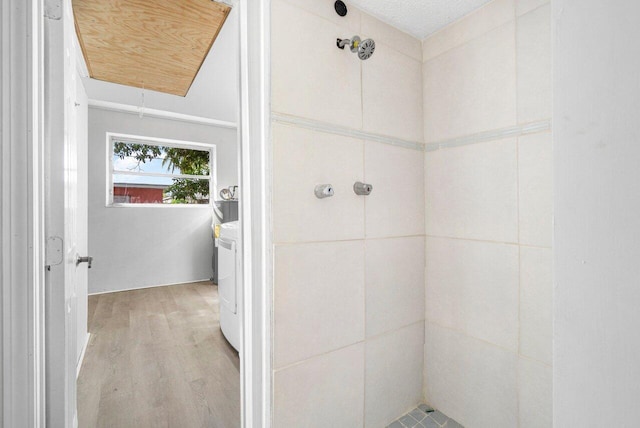 bathroom featuring wood-type flooring, washer / clothes dryer, and walk in shower