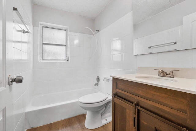 full bathroom featuring hardwood / wood-style floors, a textured ceiling, toilet, shower / tub combination, and vanity