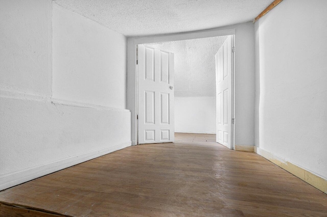 hallway featuring vaulted ceiling and a textured ceiling