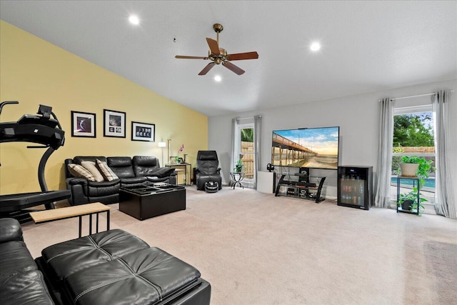 living room with ceiling fan, light colored carpet, and vaulted ceiling