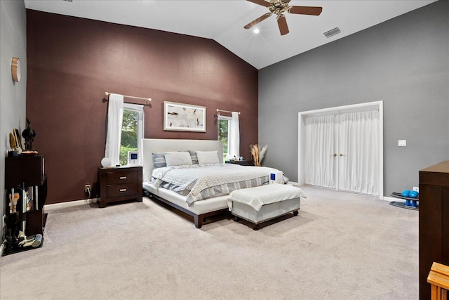 bedroom with ceiling fan, light carpet, and high vaulted ceiling