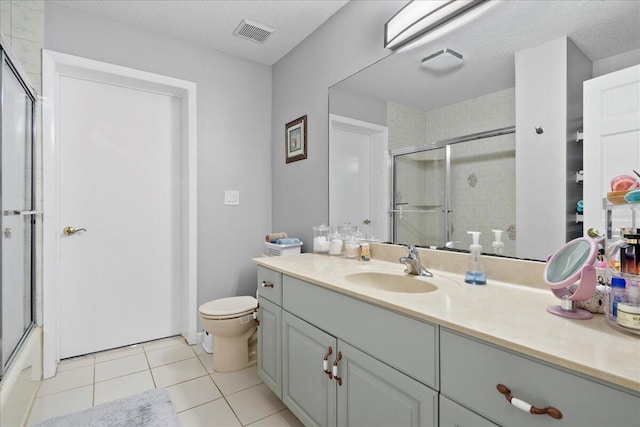 full bathroom with tile patterned floors, vanity, a textured ceiling, and toilet