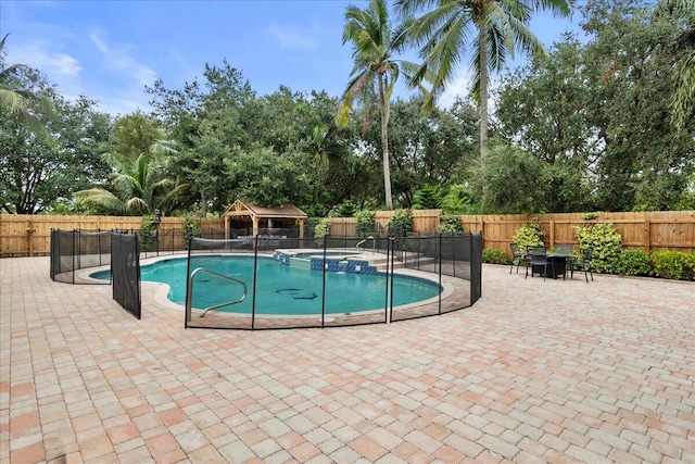 view of swimming pool featuring an in ground hot tub and a patio area