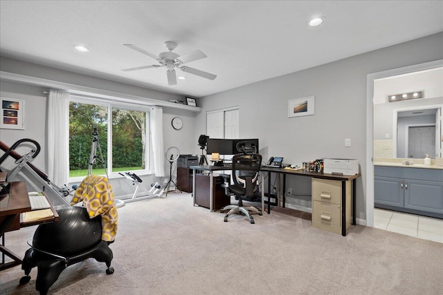 carpeted office space featuring ceiling fan