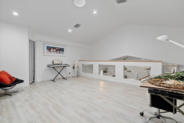 interior space featuring light wood-type flooring and vaulted ceiling