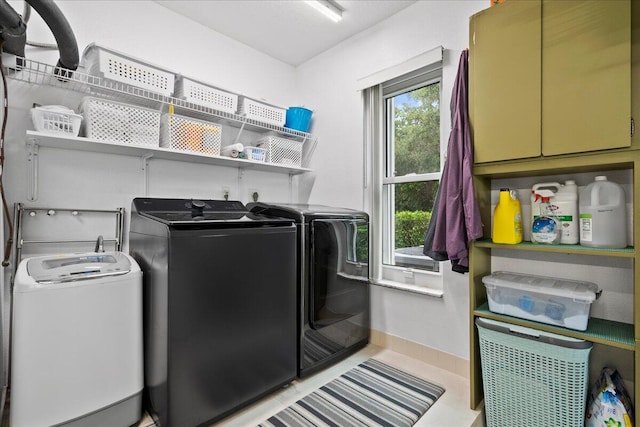 laundry area featuring light tile patterned floors and washing machine and clothes dryer