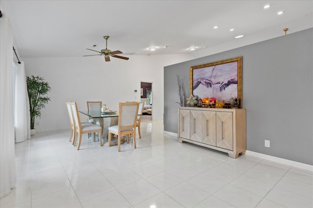 dining space featuring ceiling fan, light tile patterned floors, and vaulted ceiling