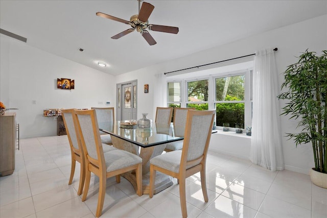 tiled dining area with ceiling fan and lofted ceiling