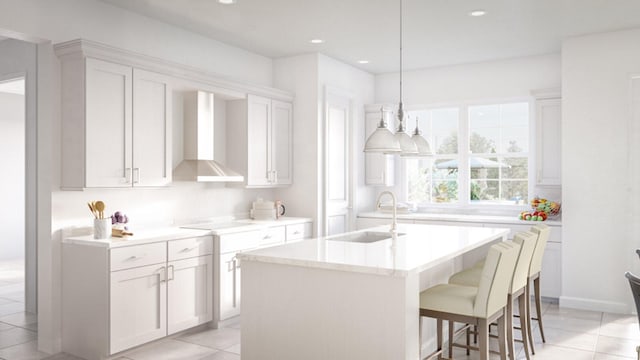 kitchen featuring white cabinetry, wall chimney exhaust hood, a center island with sink, and sink