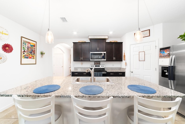 kitchen featuring dark brown cabinets, decorative light fixtures, sink, and appliances with stainless steel finishes