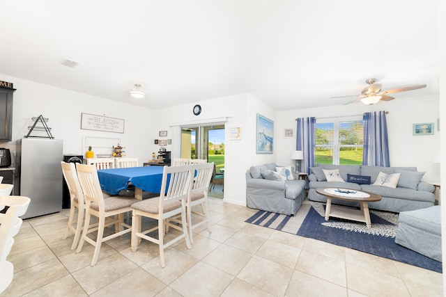 tiled dining space featuring ceiling fan and a healthy amount of sunlight