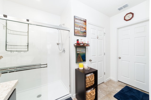 bathroom featuring tile patterned flooring, vanity, and a shower with shower door