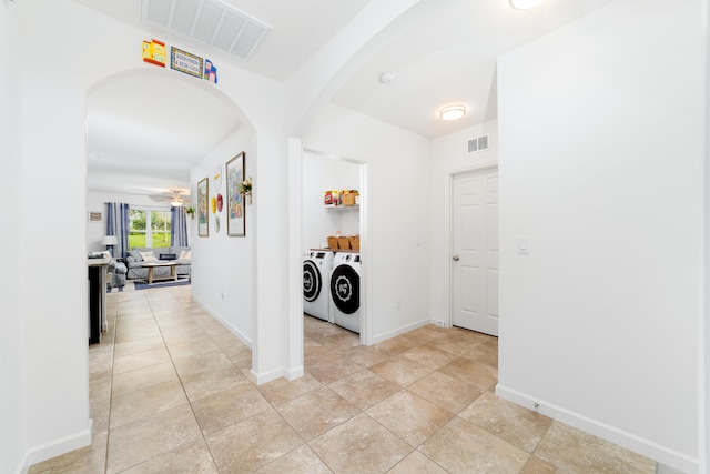 laundry room featuring light tile patterned floors, washer and clothes dryer, and ceiling fan