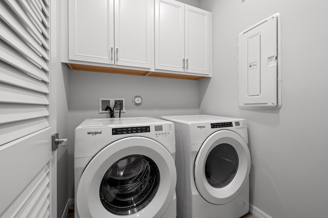 clothes washing area with electric panel, cabinets, and washing machine and clothes dryer