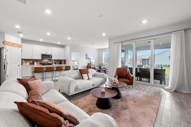 living room featuring sink and light hardwood / wood-style floors