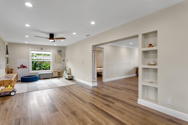 interior space featuring ceiling fan, hardwood / wood-style flooring, and built in features