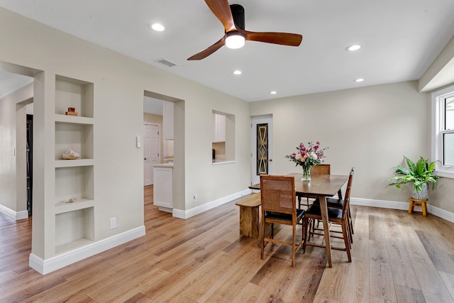 dining space featuring light wood-type flooring, built in features, and ceiling fan