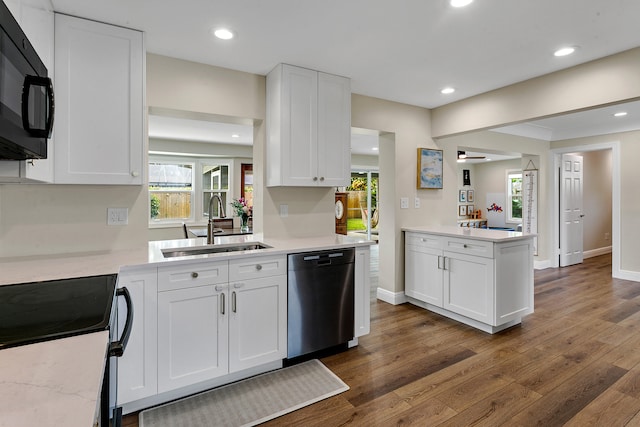 kitchen with dark hardwood / wood-style floors, sink, white cabinets, stainless steel dishwasher, and kitchen peninsula