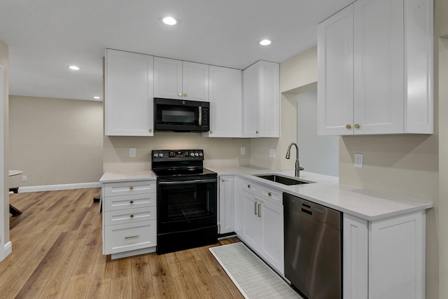 kitchen featuring white cabinets, light hardwood / wood-style flooring, black appliances, and sink