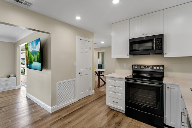 kitchen featuring black electric range, white cabinetry, and light hardwood / wood-style floors