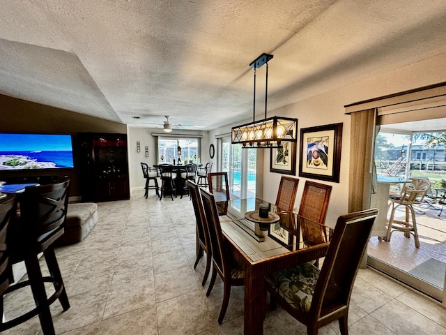 dining area with ceiling fan, a textured ceiling, and light tile patterned floors