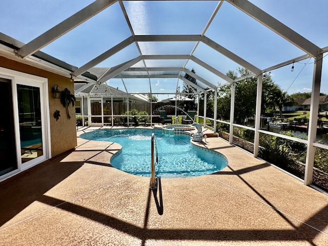 view of pool with a pool with connected hot tub, a patio area, and a lanai